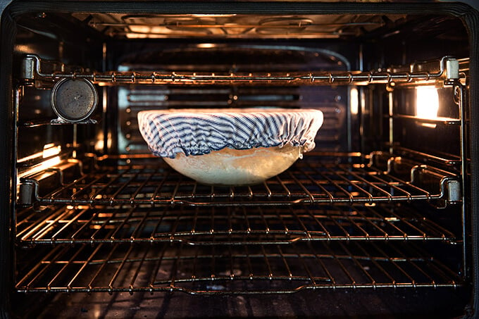 A bowl with rising dough in a warm oven.