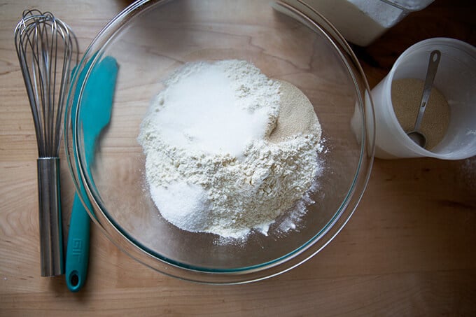 An overhead shot of a glass bowl with the dry ingredients for the buttermilk pull-apart rolls.