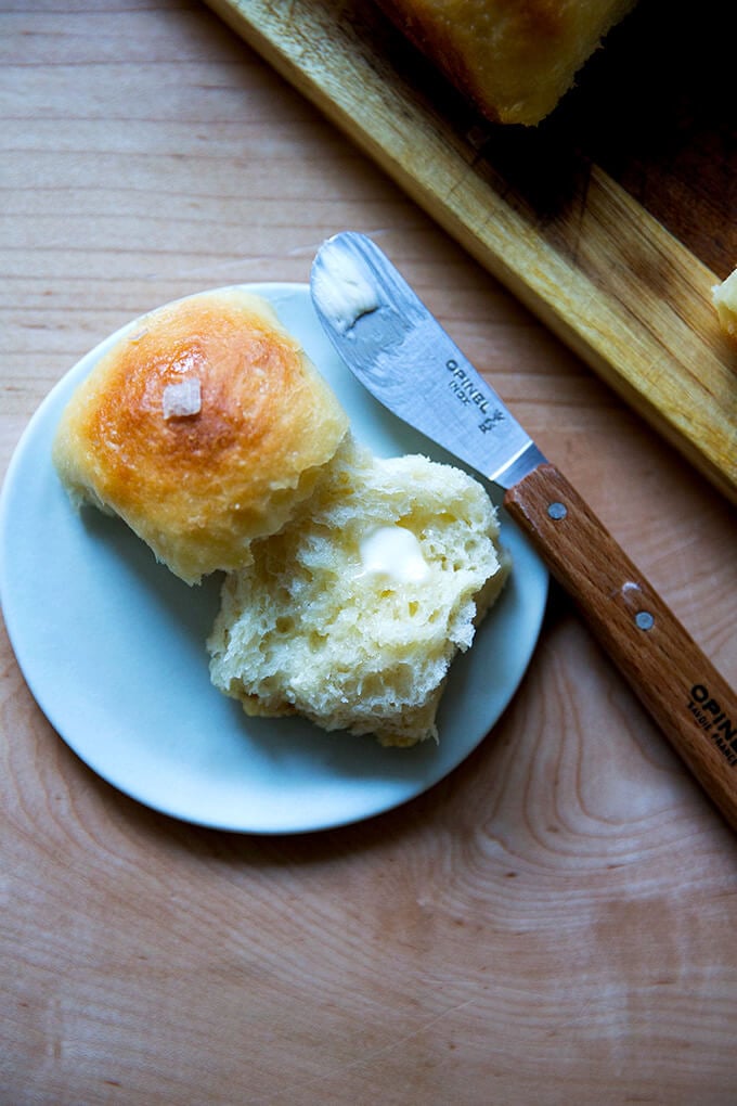 A buttermilk pull-apart roll on a plate spread with butter.