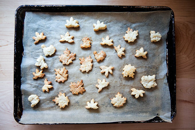 A sheet pan lined with parchment paper topped with baked pie cookies.