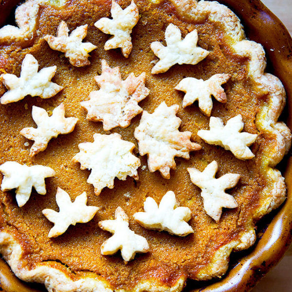 A pumpkin pie decorated with pie cookies.