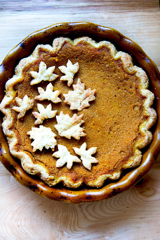 A pumpkin pie decorated with pie cookies.