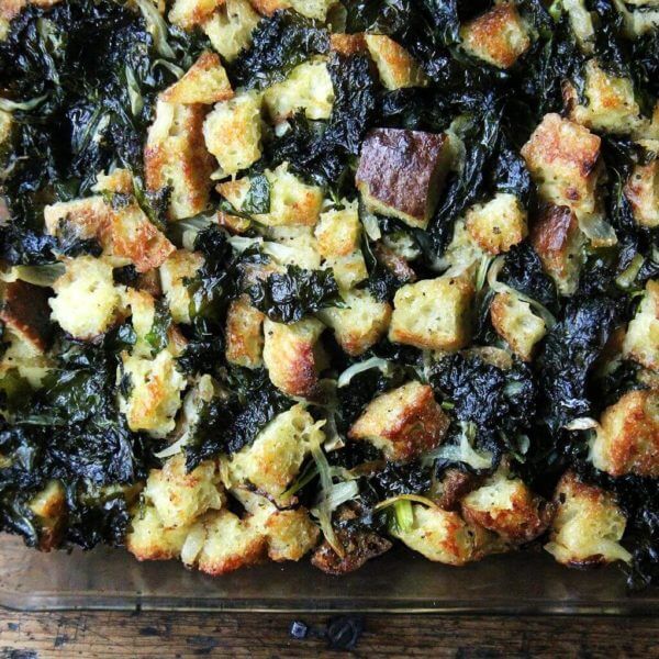 An overhead shot of just-baked kale and caramelized onions in a 9x13-inch pan.
