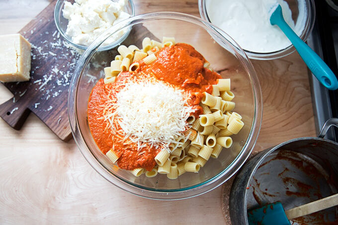 A large bowl filled with cooked pasta, vodka sauce, and parmesan.