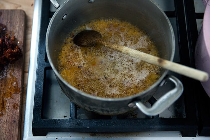A saucepan filled with butter, garlic, red pepper flakes and vodka.