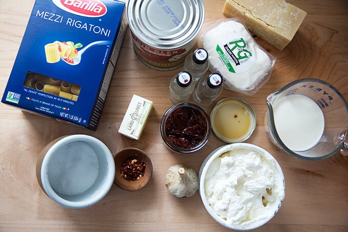 Ingredients to make baked penne alla vodka sauce on a countertop.