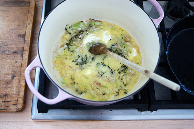 A pot filled with melted butter, shallots, celery, thyme, wine and crème fraîche.