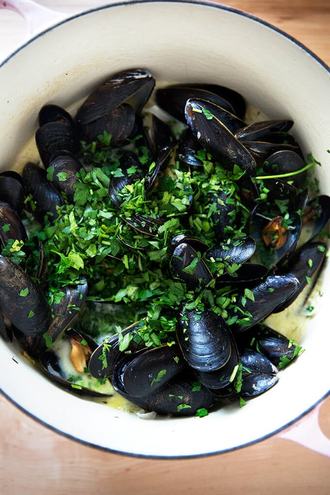 A pot of mussels, just steamed, sprinkled with parsley.