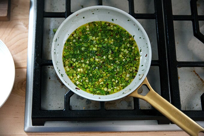 A small skillet holding scallion oil.