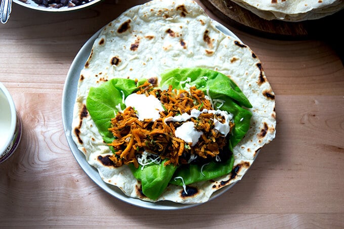 An overhead shot of a sweet potato and black bean burrito, unrolled.