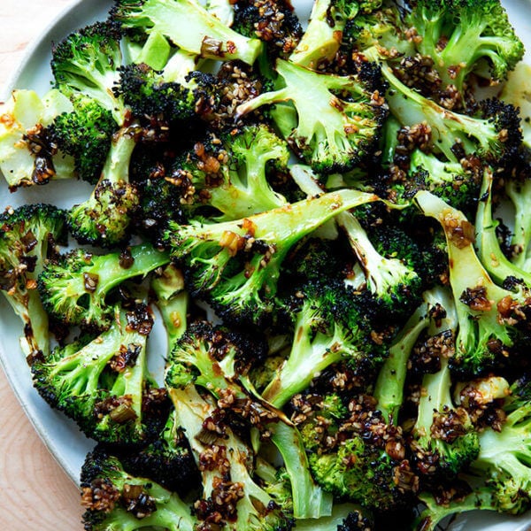 Spicy broiled broccoli with sesame-scallion oil on a plate.