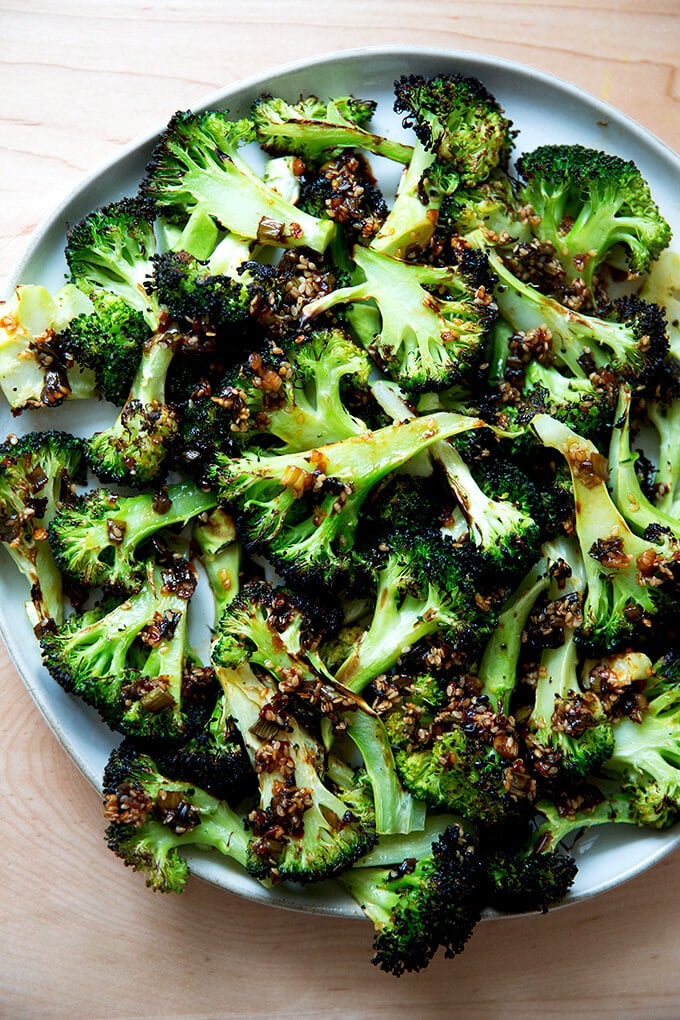 Spicy broiled broccoli with sesame-scallion oil on a plate.