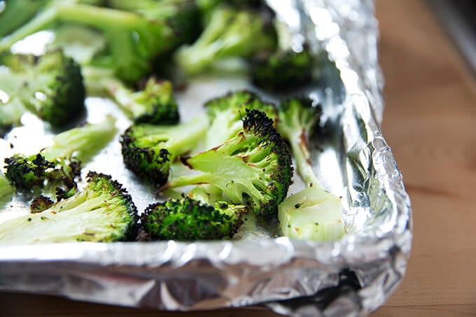 Broiled broccoli on a sheet pan.
