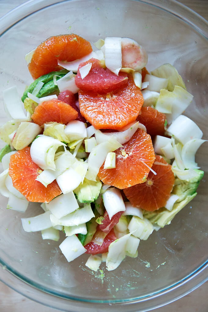 Citrus, avocado, endive in a bowl, seasoned with sea salt and tossed together.