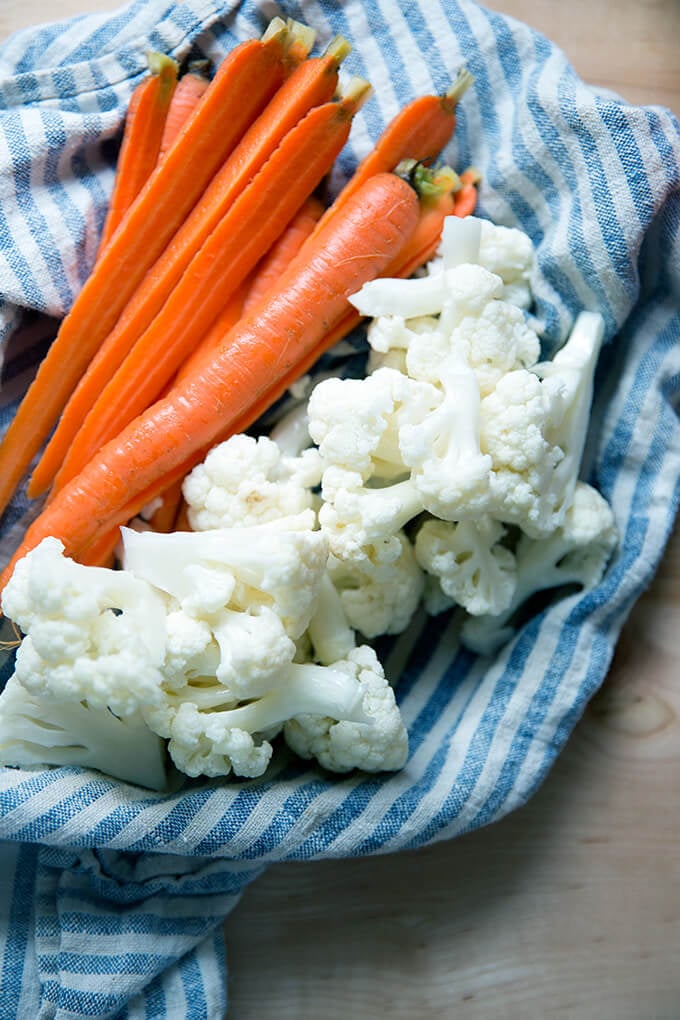 A tea towel drying off pickled carrots and cauliflower.