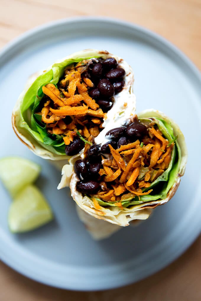 Overhead shot of halved sweet potato and black bean burrito.