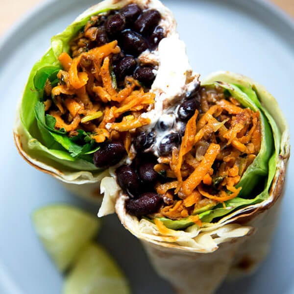 Overhead shot of halved sweet potato and black bean burrito.