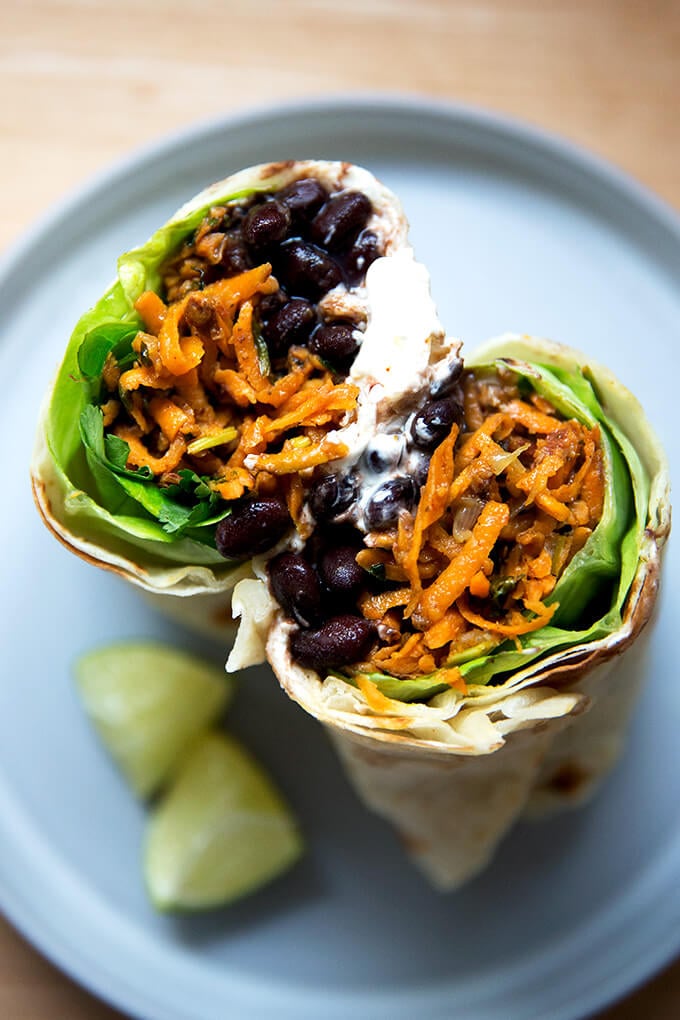 Overhead shot of halved sweet potato and black bean burrito.