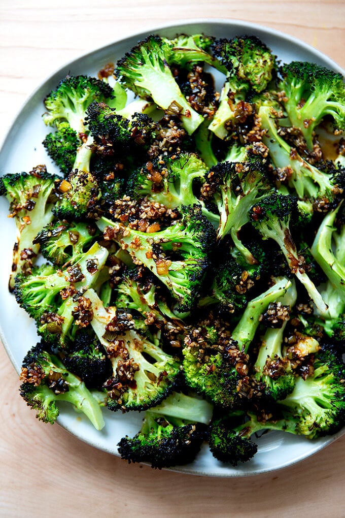 Spicy broiled broccoli with sesame-scallion oil on a plate.