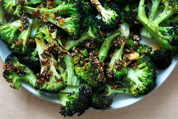 Spicy broiled broccoli with sesame-scallion oil on a plate.