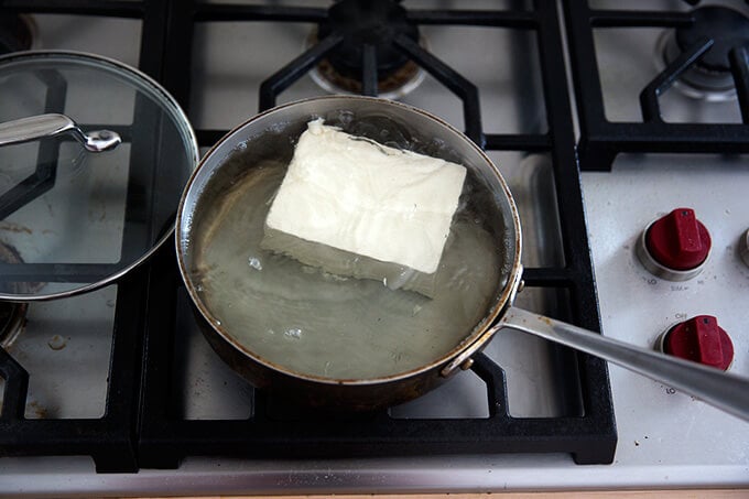 a block of tofu simmering in water.