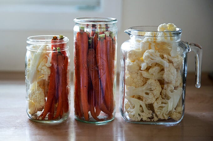 Glass jars filled with pickled crudité.