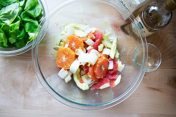 A bowl of citrus segments, avocado, endive, sea salt, and white balsamic vinegar.