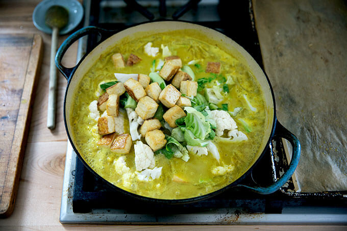 A stovetop skillet with a cauliflower tofu curry in it.