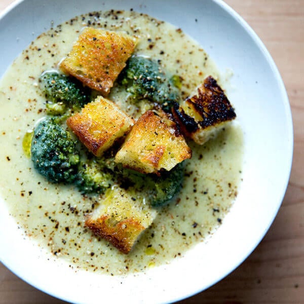 A bowl of broccoli-cheddar soup with olive oil toasted croutons.