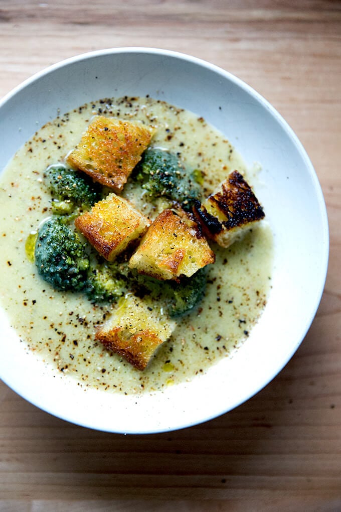 A bowl of broccoli-cheddar soup with olive oil toasted croutons.
