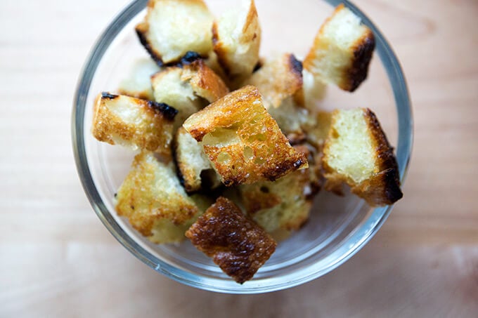 Olive oil toasted cubes of day old bread in a bowl for soup.