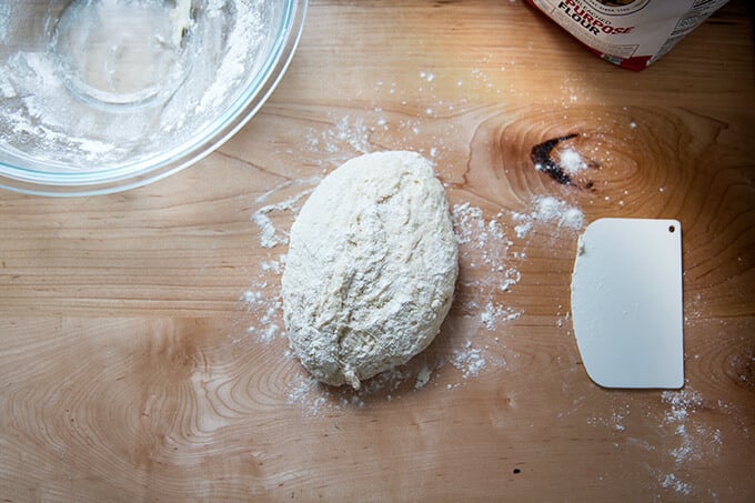 Risen naan dough turned out onto a work surface.