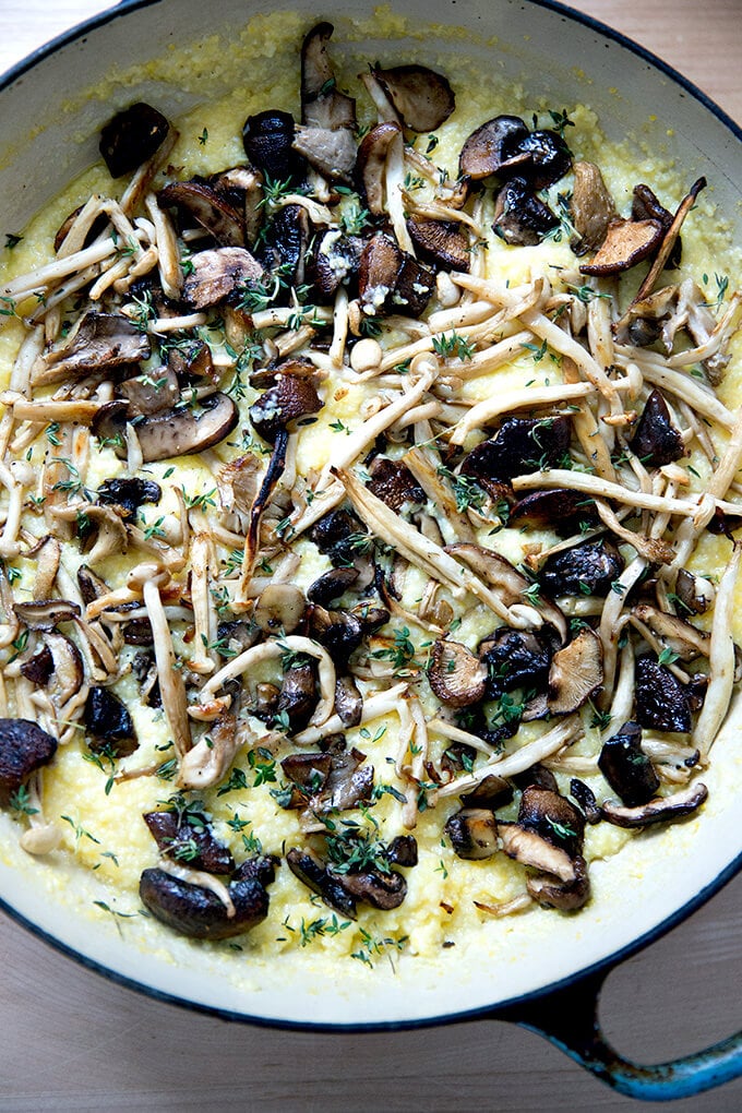 A skillet of polenta topped with roasted mushrooms.