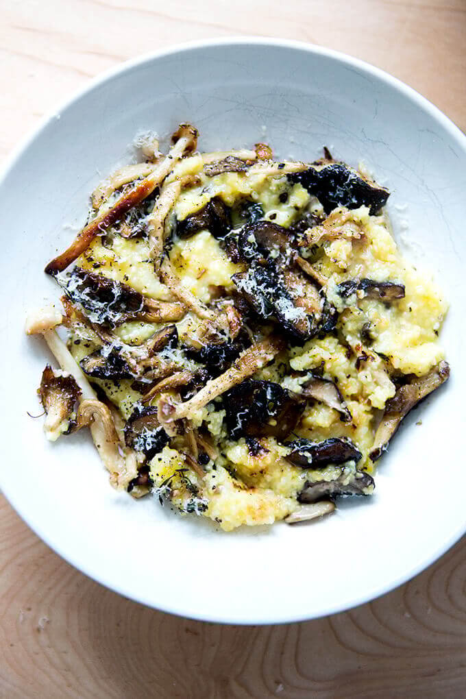 A bowl of roasted mushroom polenta bake topped with parmesan cheese and pepper.