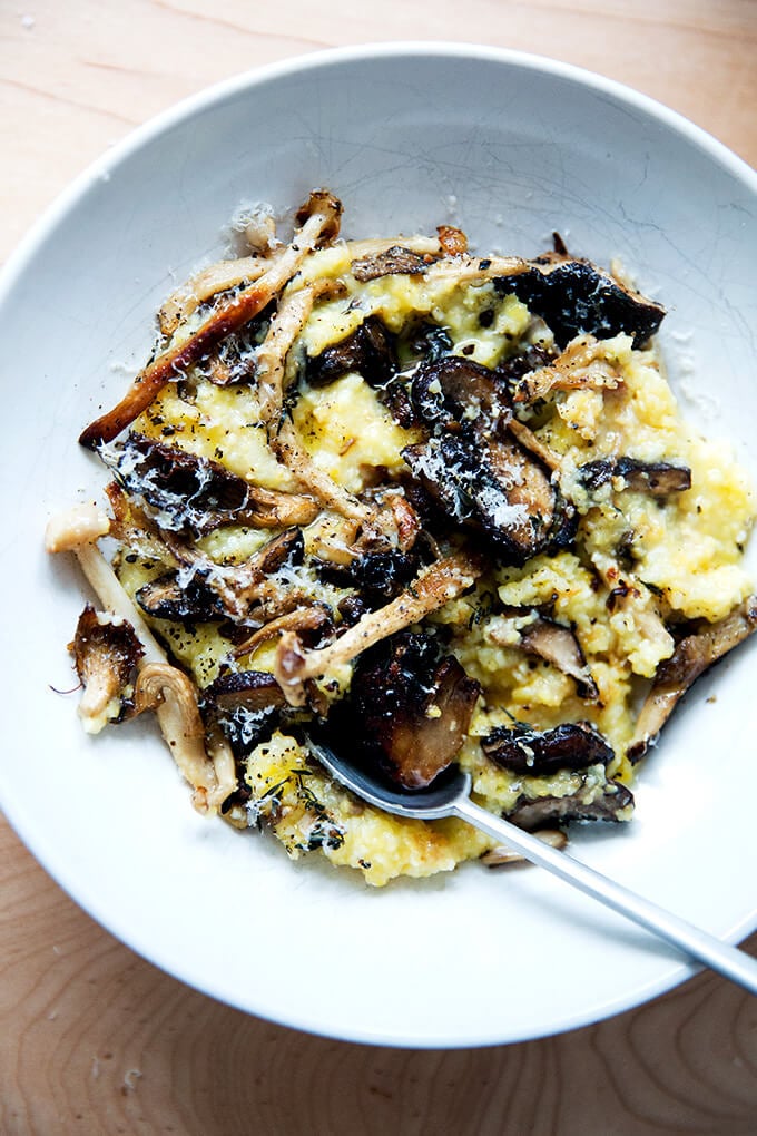 A bowl of roasted mushroom polenta bake with a spoon in it.