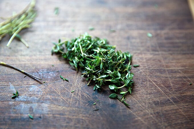 Thyme leaves on a cutting board.