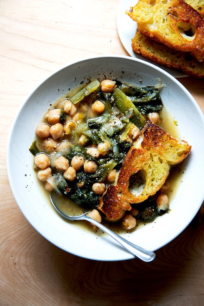 A bowl of chickpea and escarole soup with toasty bread.