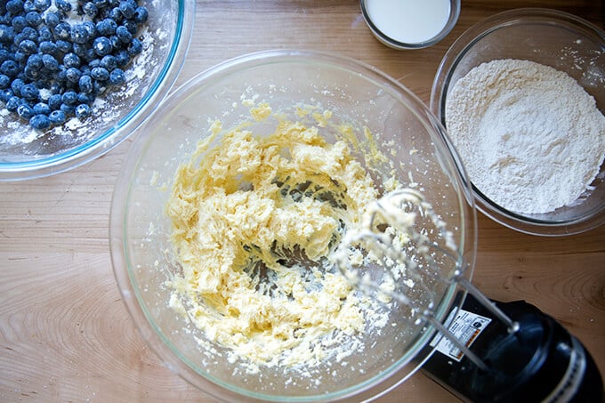 An overhead shot of a handheld mixer creaming butter and sugar.