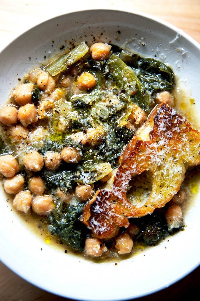 A bowl of chickpea and escarole soup with toasty bread.