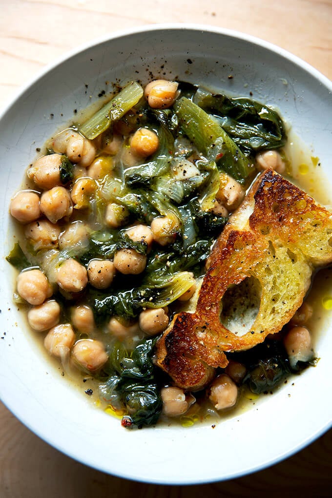 A bowl of chickpea and escarole soup with toasty bread.