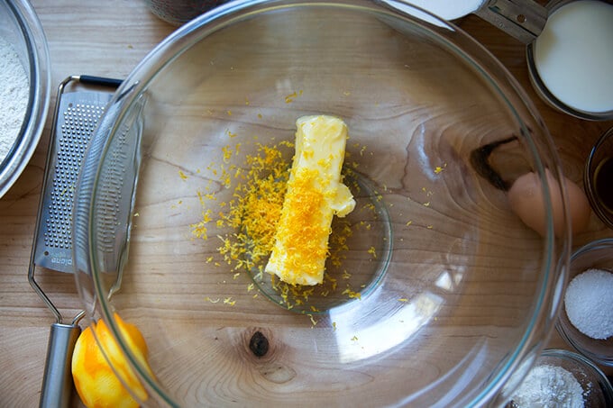 A bowl with a stick of butter and lemon zest in it.