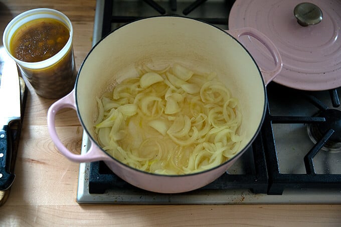 Sliced onions sautéing stovetop.