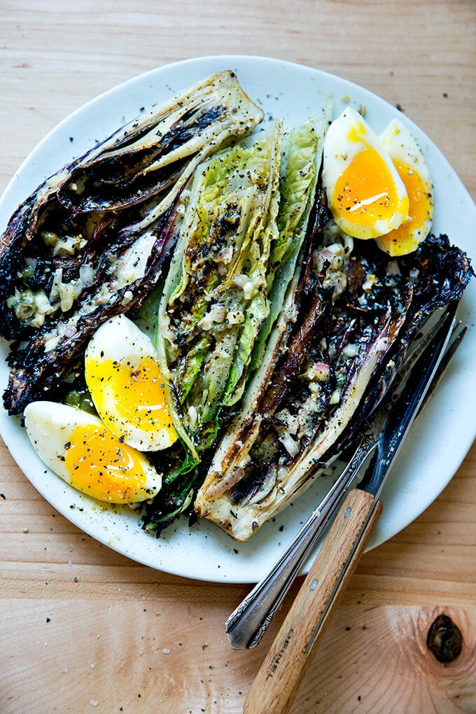 A plate of grilled Romaine salad with soft-boiled eggs. 
