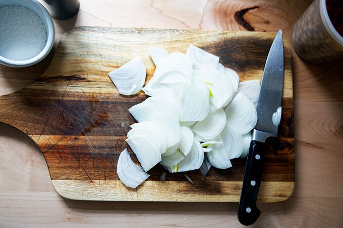 Sliced onions on a board.