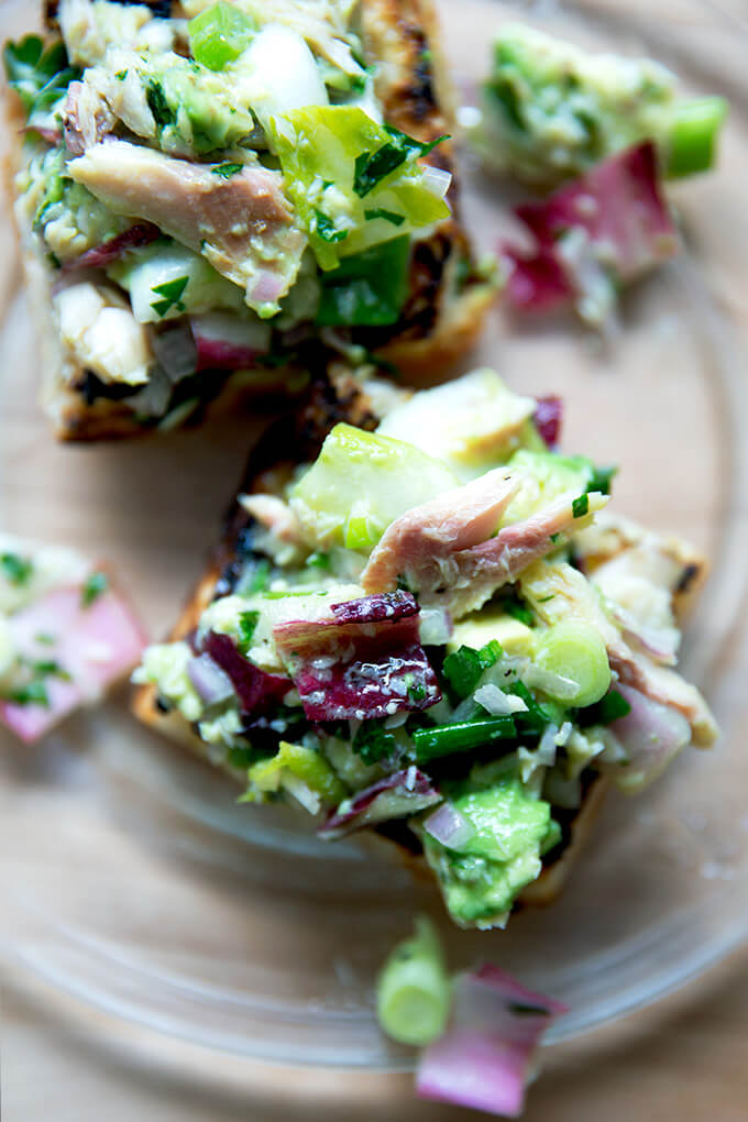 An overhead shot of a smoked trout and avocado salad on toasty bread.
