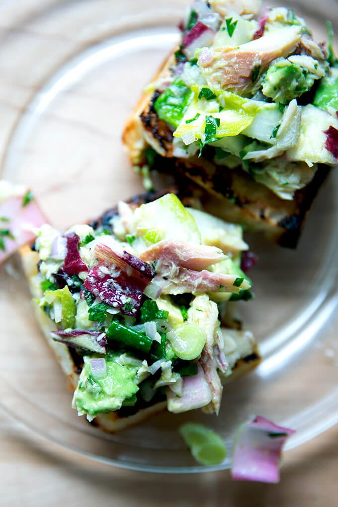 An overhead shot of a smoked trout and avocado salad on toasty bread.