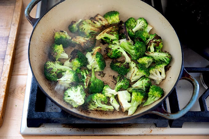 A sauté pan filled with charred broccoli.