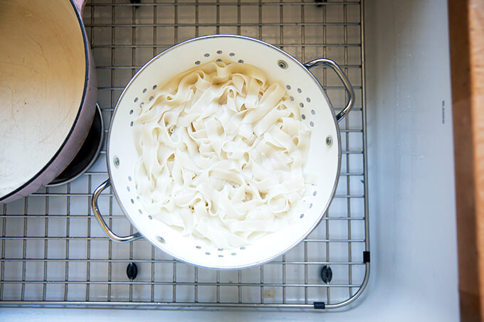 Noodles drained in a colander in the sink.