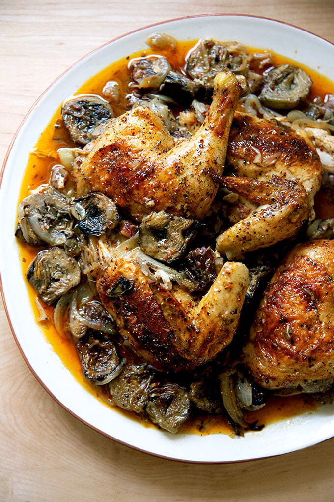 A platter of roast chicken with dates and artichoke hearts.