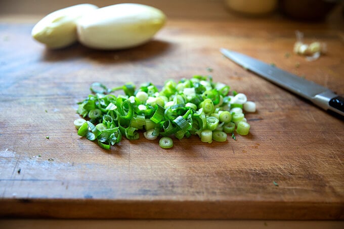 Chopped scallions on a board.